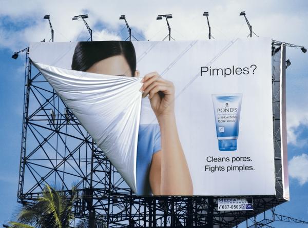 This image shows a hoarding with a woman hiding her face in Ponds ads