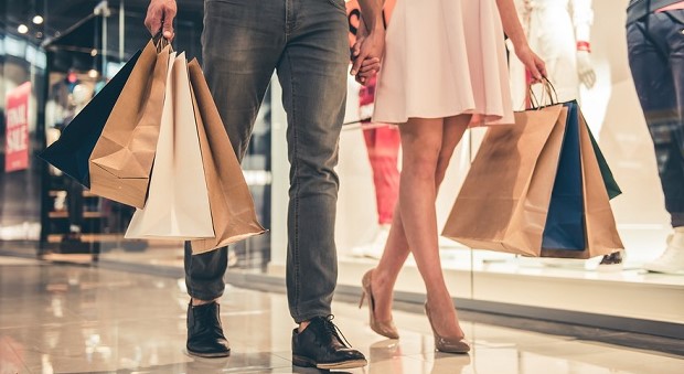 A picture showing offline marketing activities via two people walking in front of a store with shopping bags