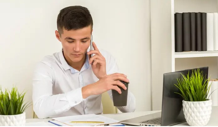 A picture showing a man attending phone calls in his office