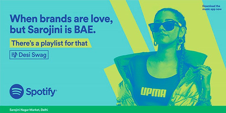 This image shows a woman in the “There’s a playlist for that” campaign by Spotify on a blue background