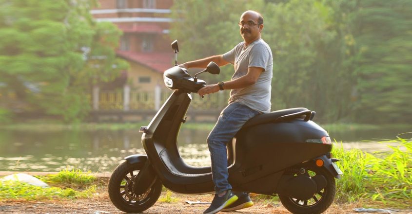 This image depicts a person on an Electric scooter Ola