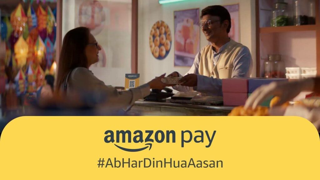 This image shows a shopkeeper and a woman paying through Amazon Pay
