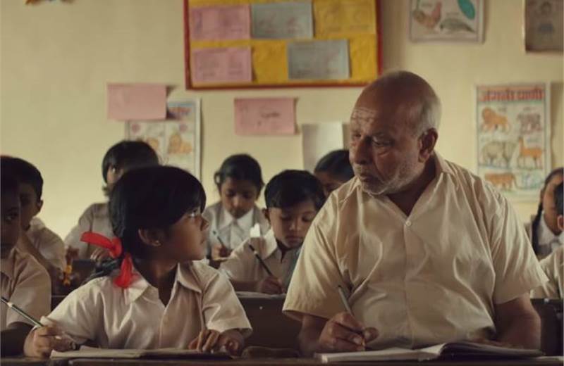This image features an old man in a class of children studying together as a part of #DontLetYourDreamsWait P&G Siksha’s marketing campaign