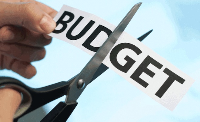 This image shows a person cutting the budget in a blue background
