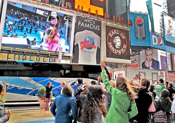 A huge group of the audience looking at the billboard.