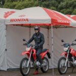 A man using a promotional Umbrella as a shed